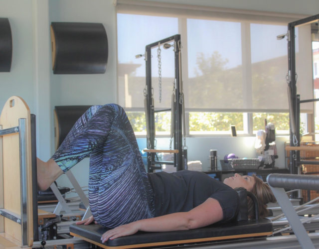 woman doing pilates on a reformer